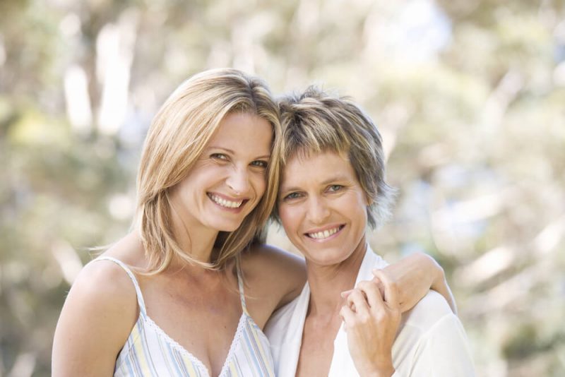 Two smiling women outside