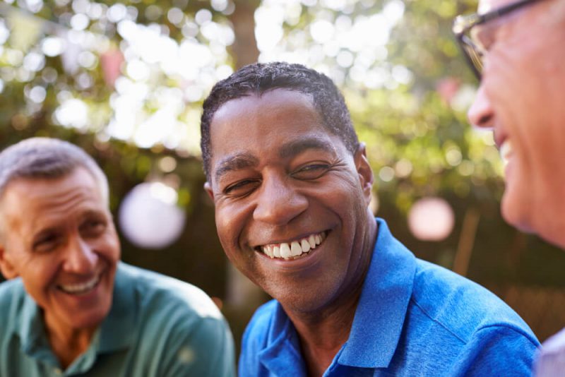 Man smiling with friends outside