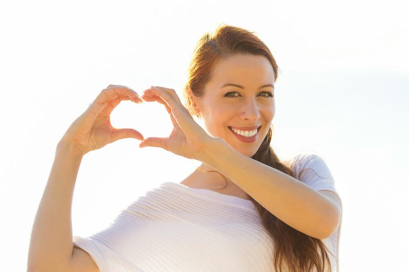 Smiling woman making a heart with her hands